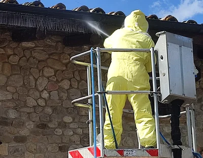 Disinfestazione vespe su tetto con piattaforma aerea Operatore in tuta protettiva che effettua la disinfestazione di vespe sul tetto usando una piattaforma aerea e motopompa ad alta pressione.